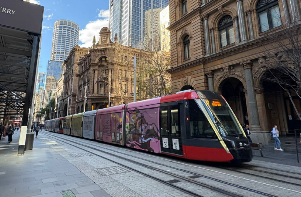 A tram with a wrap advertising the Sydney Everest Carnival is shown in the Sydney CBD.