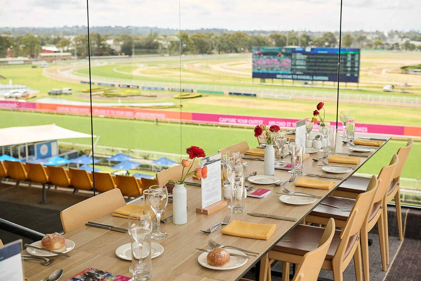 A empty table in a restaurant overlooking the track at a racecourse