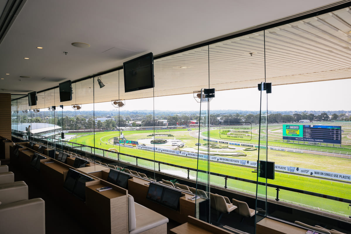 Inside view of a private suite at Rosehill Gardens racecourse, looking out at the track.