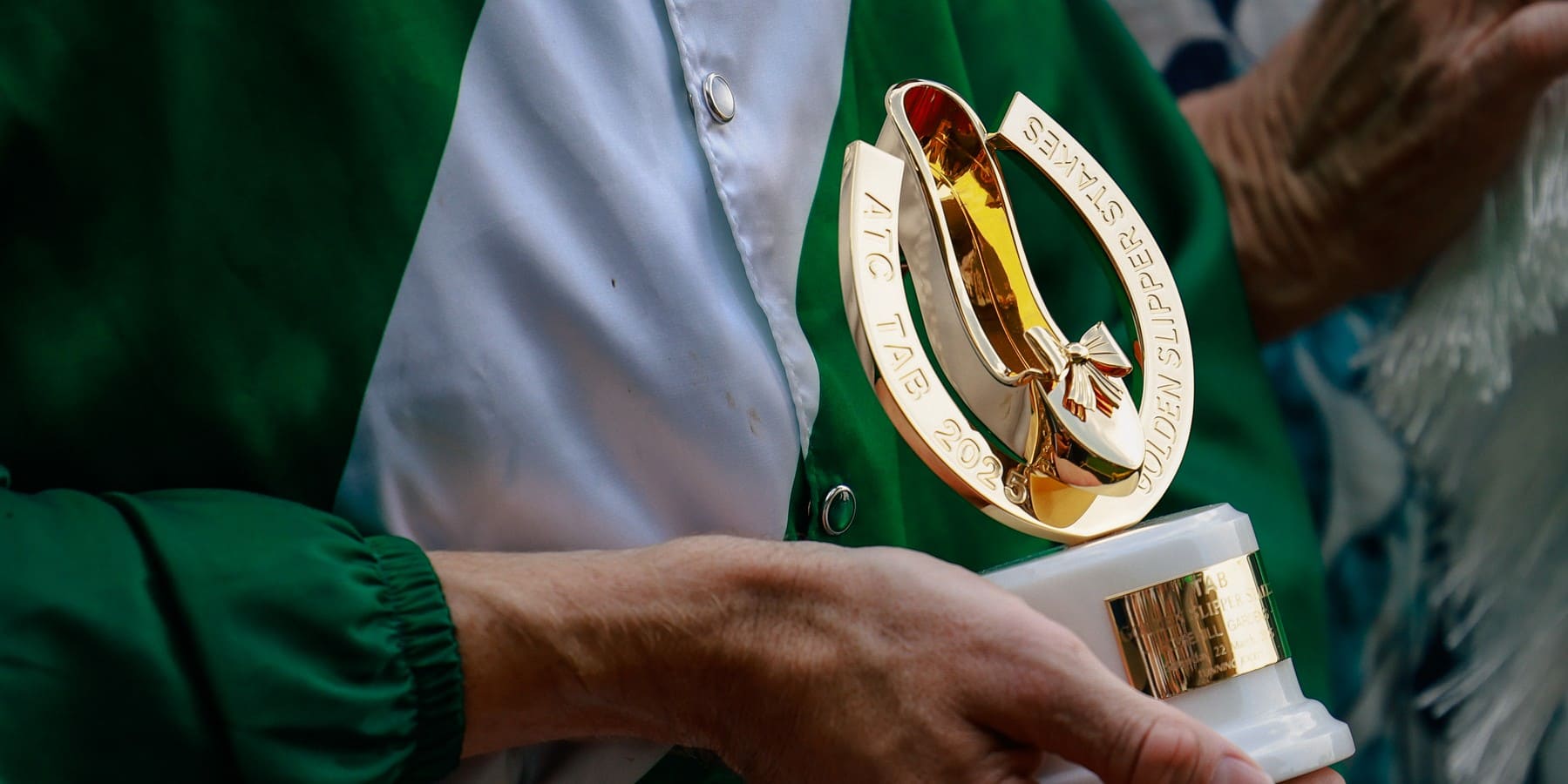 Close up of jockey Damien Lane holding the Golden Slipper trophy.